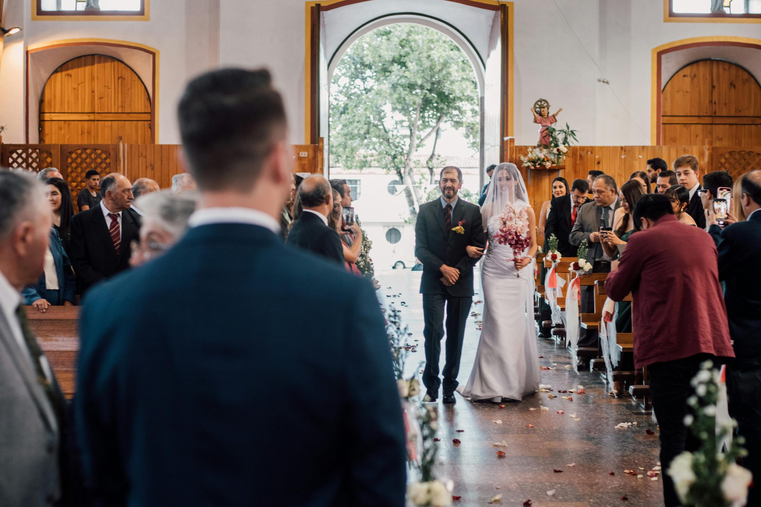 Bride and father walking down the aisle in a traditional indoor wedding ceremony.